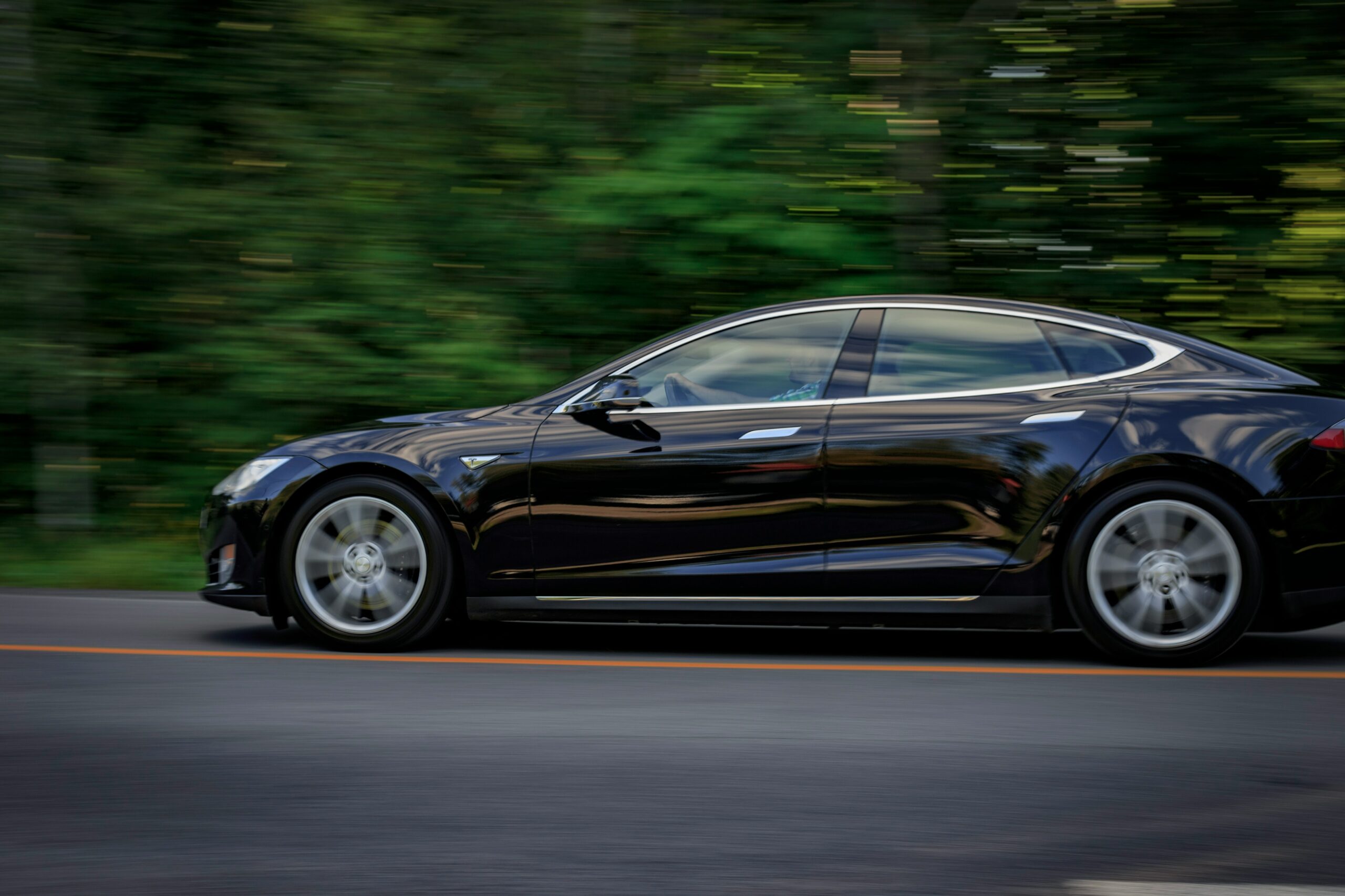 Sort Tesla Model X på en vej.