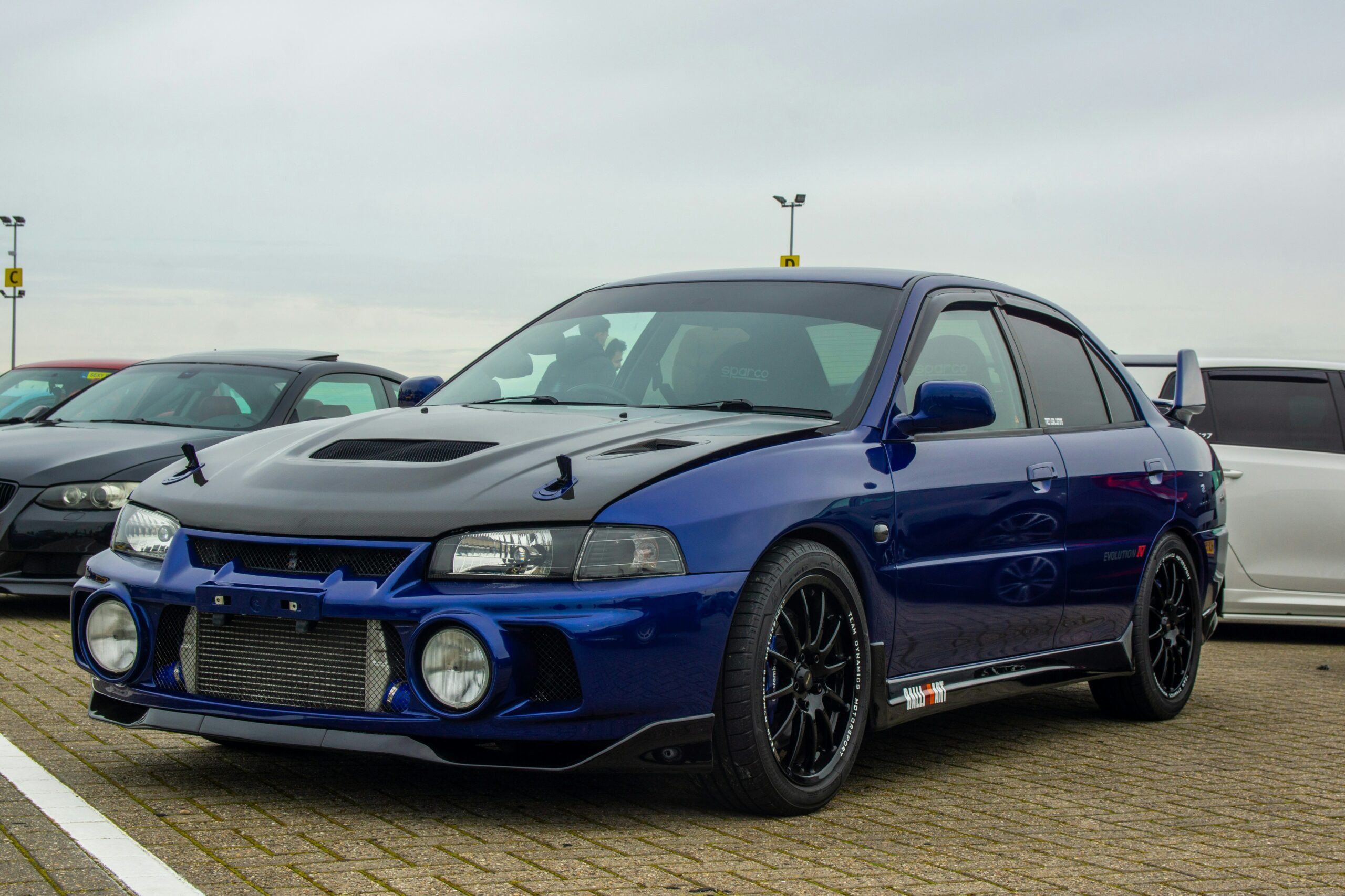 Blå Mitsubishi Lancer Evolution på en parkeringsplads.