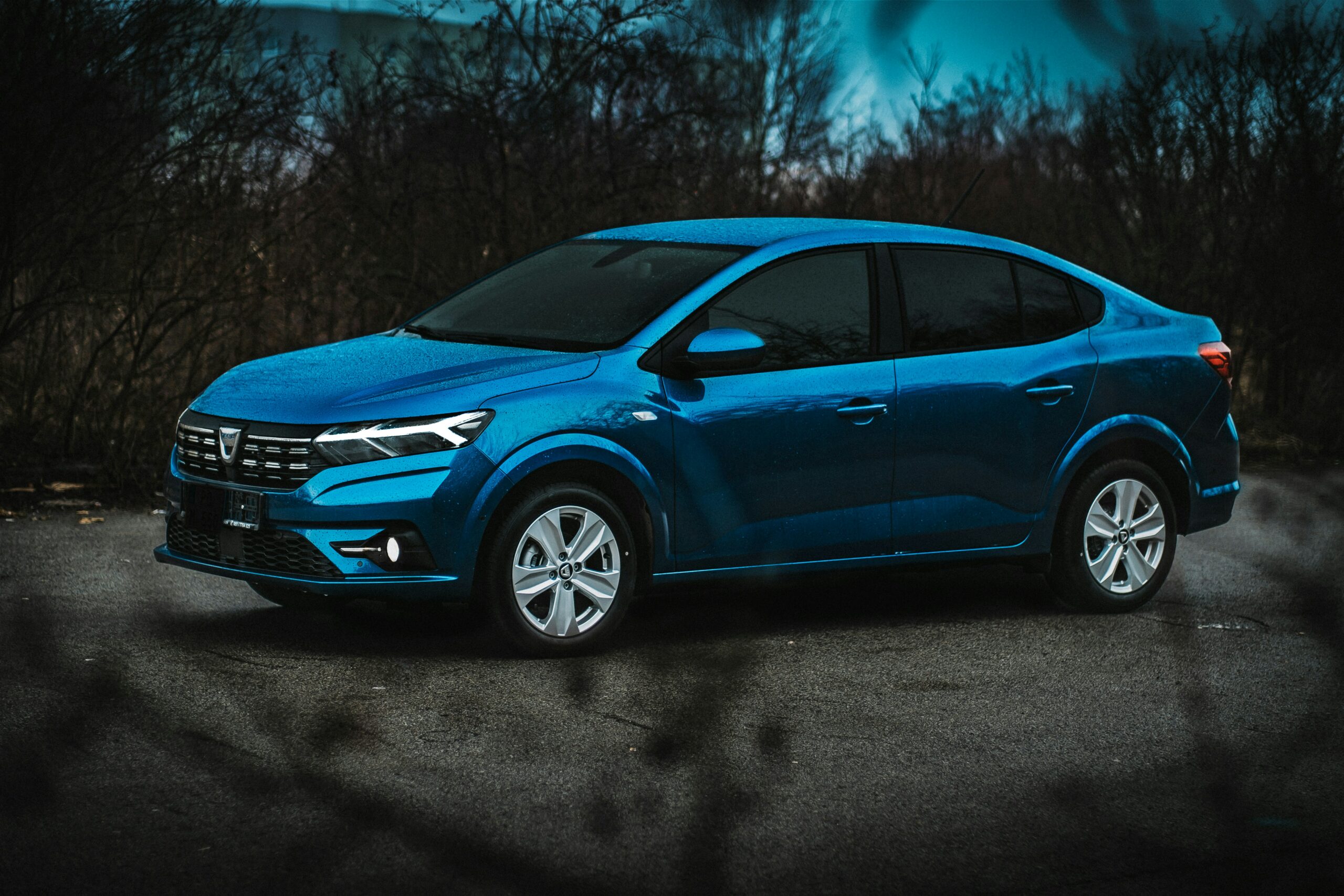 Blå Dacia set fra siden i skumringslys