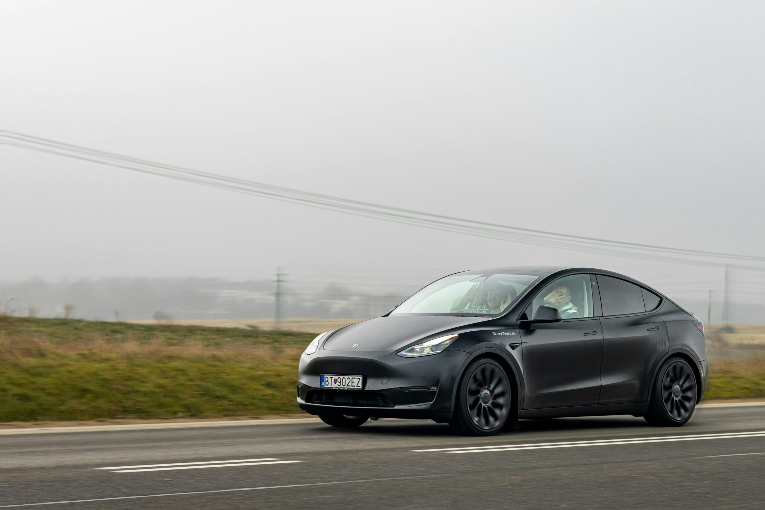 Sort Tesla Model Y på en landevej.