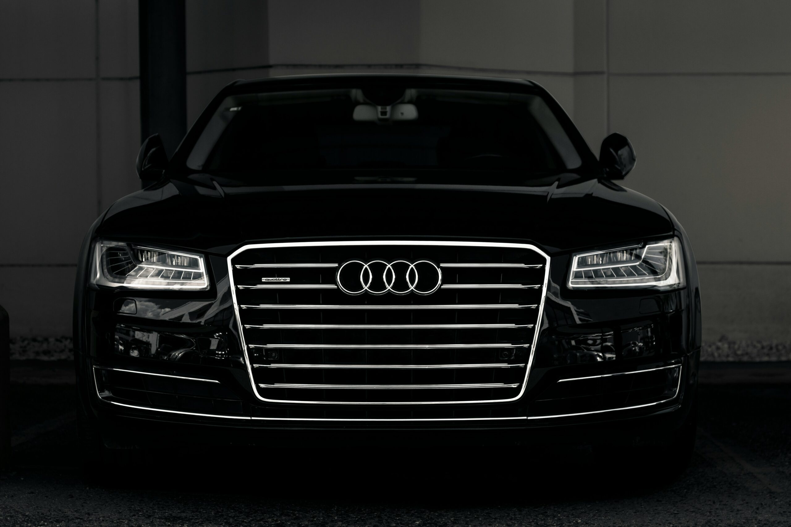 Sort Audi (quattro) set forfra i tæt nærbillede med tændte forlygter