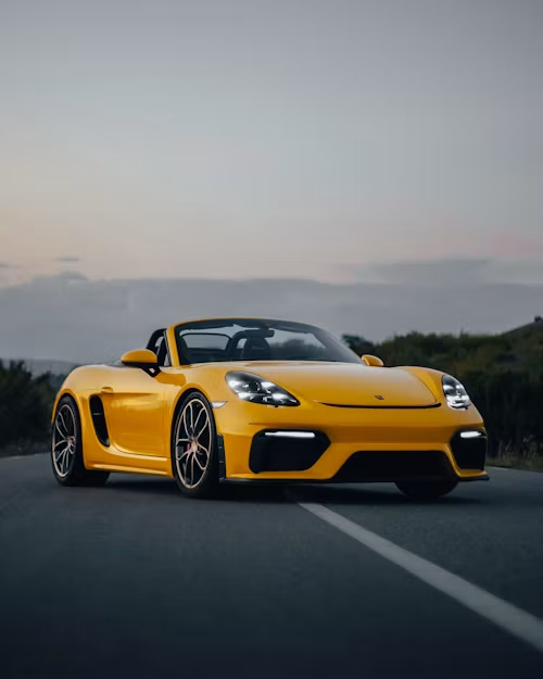 Gul Porsche 718 Spyder RS på landevej.